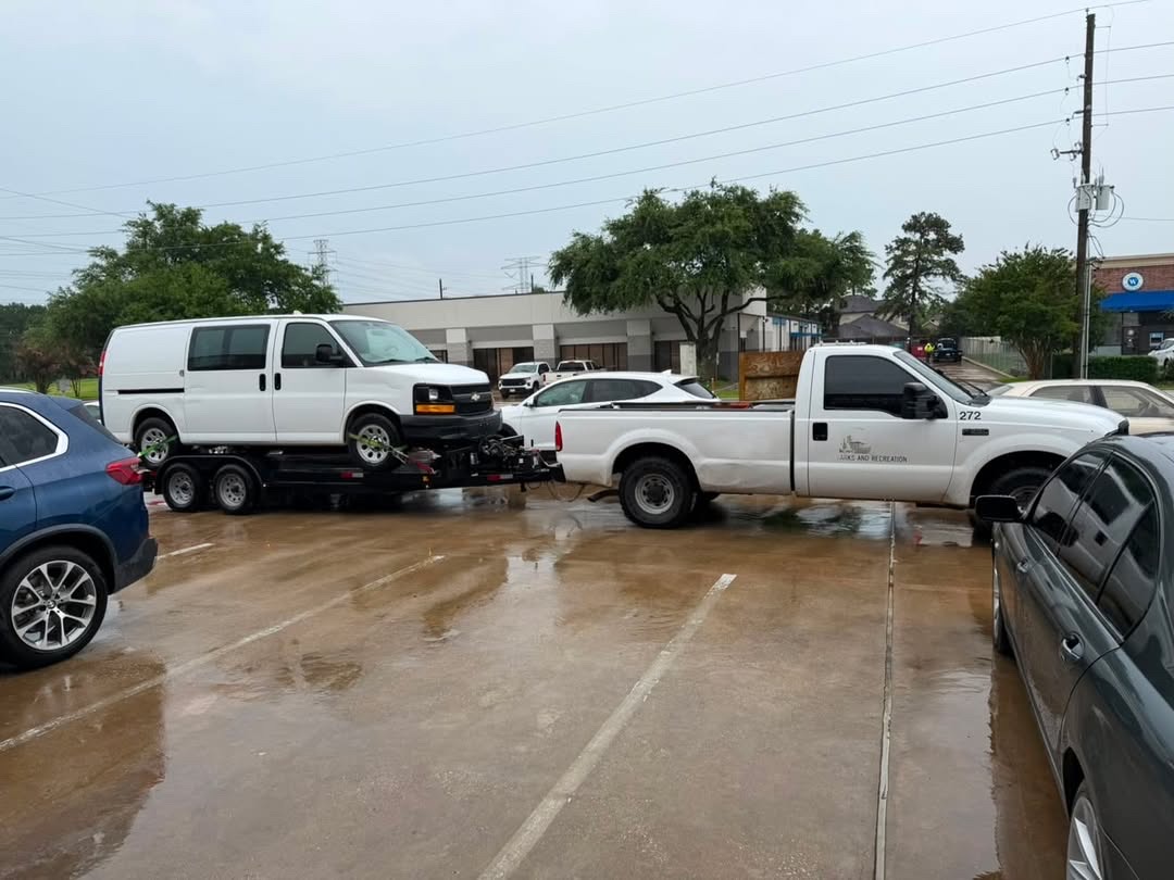 Cargo van secured on a Masterkey Transport trailer during a rainy Houston fleet transport