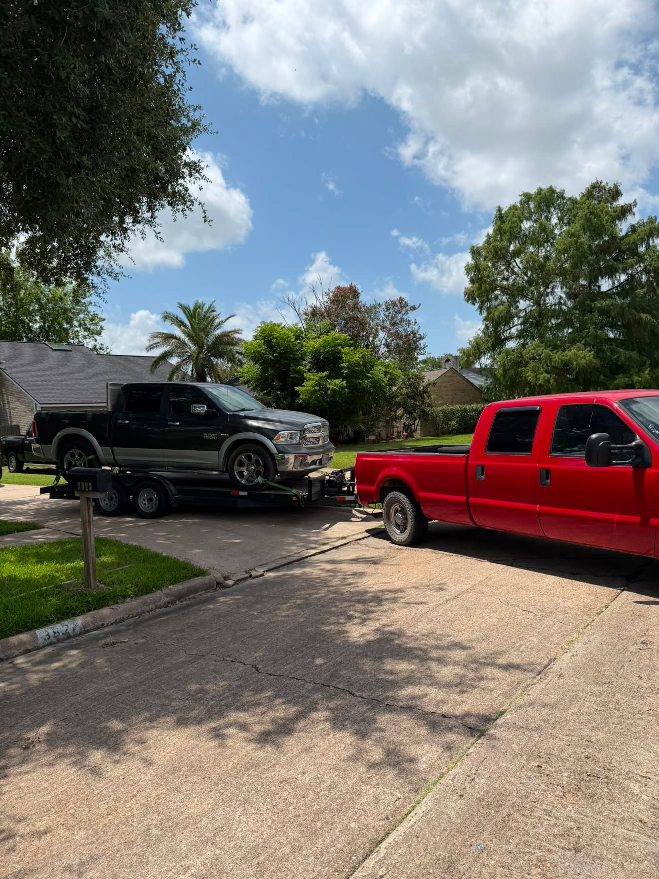 Ram 1500 pickup being towed from a Houston residential driveway by Masterkey Transport