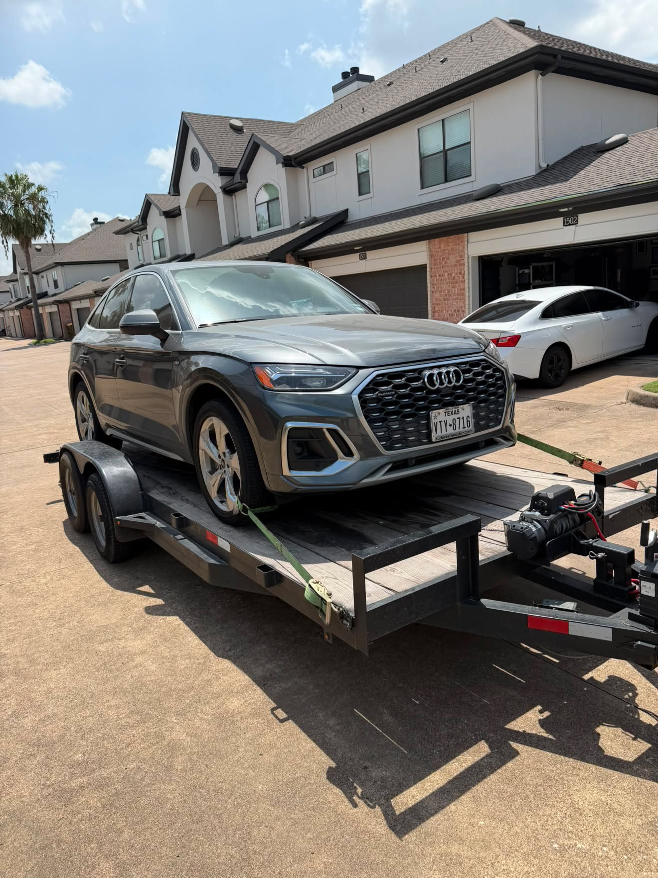 Audi Q5 loaded on a Masterkey Transport trailer outside a Houston townhome