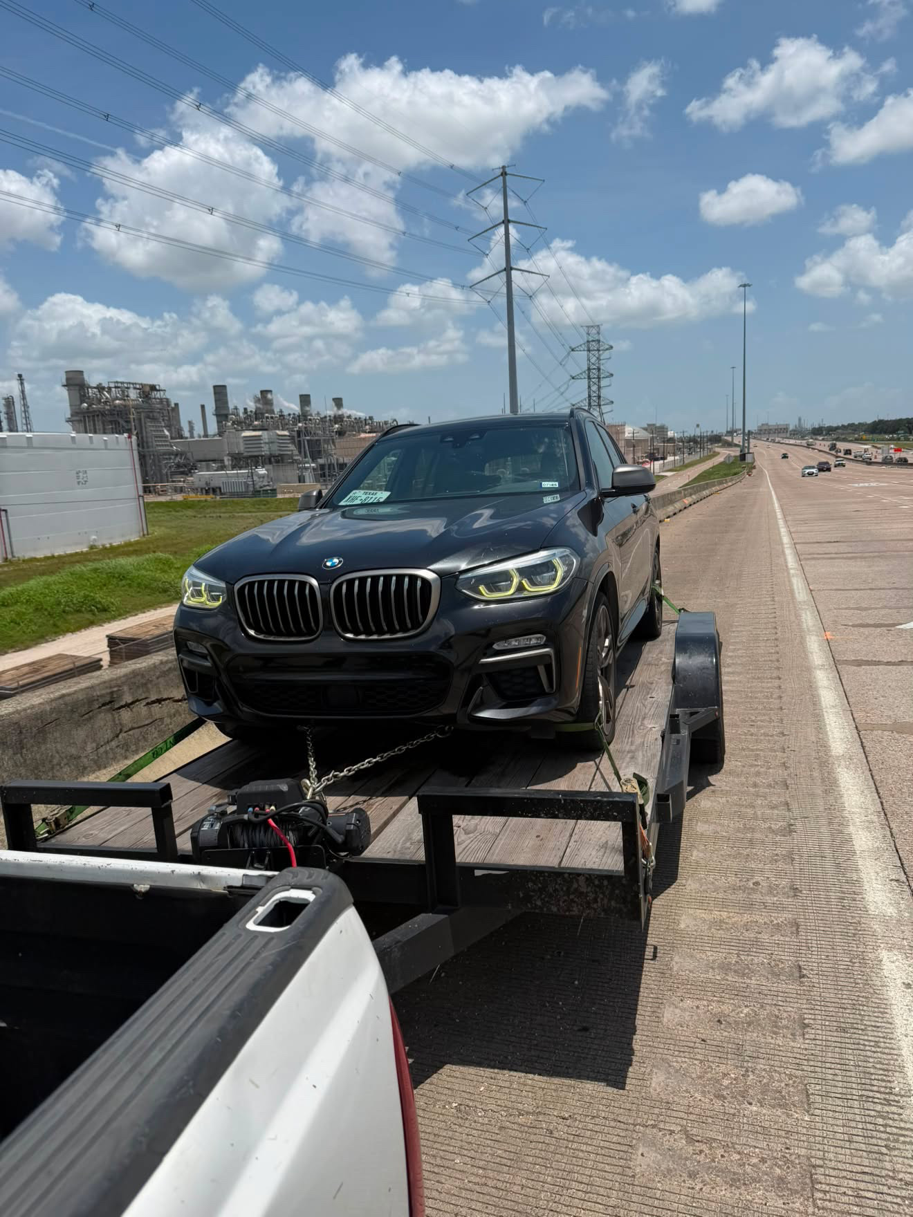 BMW X3 strapped down on a Masterkey Transport trailer on a Houston highway